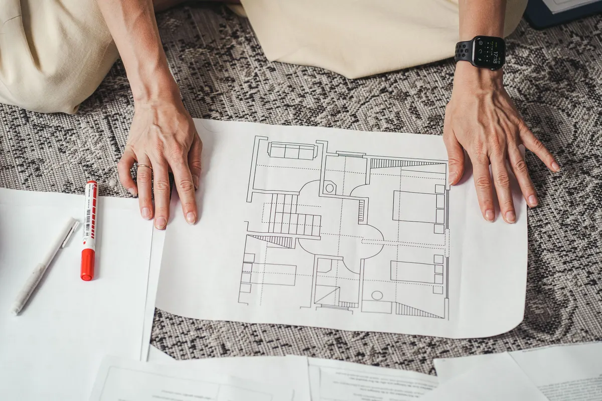 Hands resting on a printed house floor plan